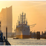 Hamburg, Landungsbrücken. Elbphilharmonie, Cap San Diego und HMS Sutherland im Sonnenaufgang.