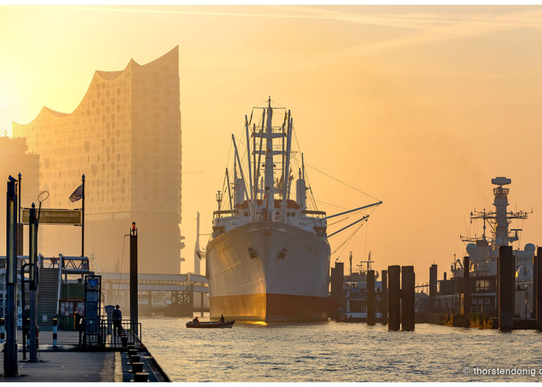 Hamburg, Landungsbrücken. Elbphilharmonie, Cap San Diego und HMS Sutherland im Sonnenaufgang.
