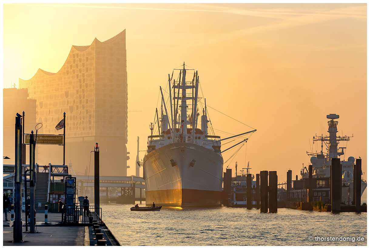 Hamburg, Landungsbrücken. Elbphilharmonie, Cap San Diego und HMS Sutherland im Sonnenaufgang.